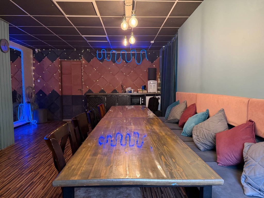 Стол для игры в мафию и мягкая зона в студии