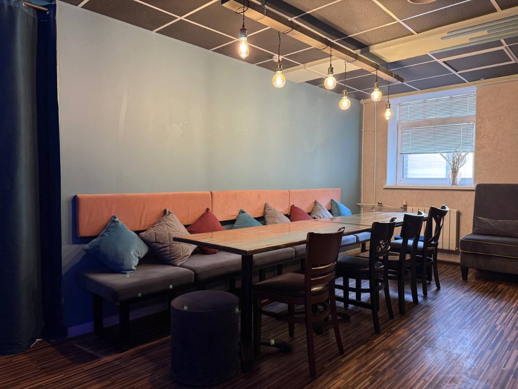 Игровая зона студии с длинным столом и посадкой для компании